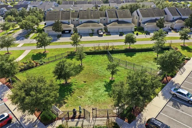 an aerial view of residential houses with outdoor space and parking