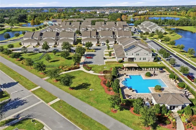an aerial view of a house with swimming pool and lake view