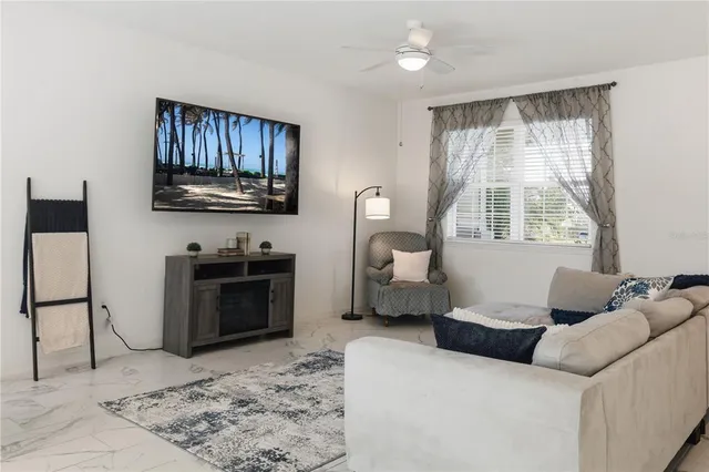 a living room with furniture a flat screen tv and a window
