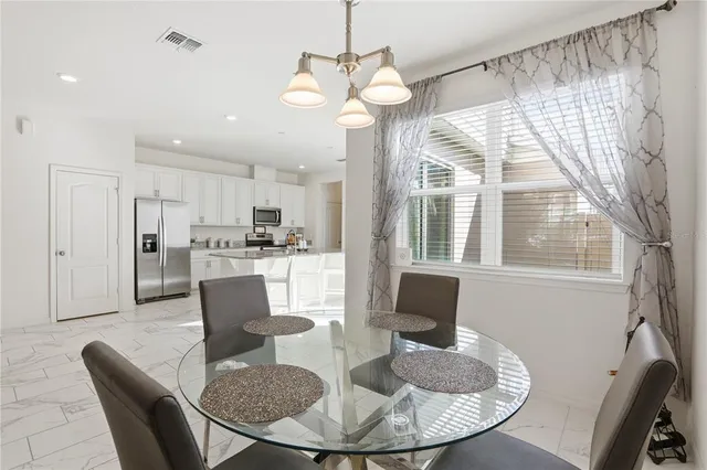 a view of a dining room with furniture a chandelier and wooden floor