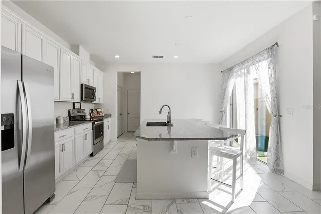 a kitchen with stainless steel appliances granite countertop a refrigerator and a sink