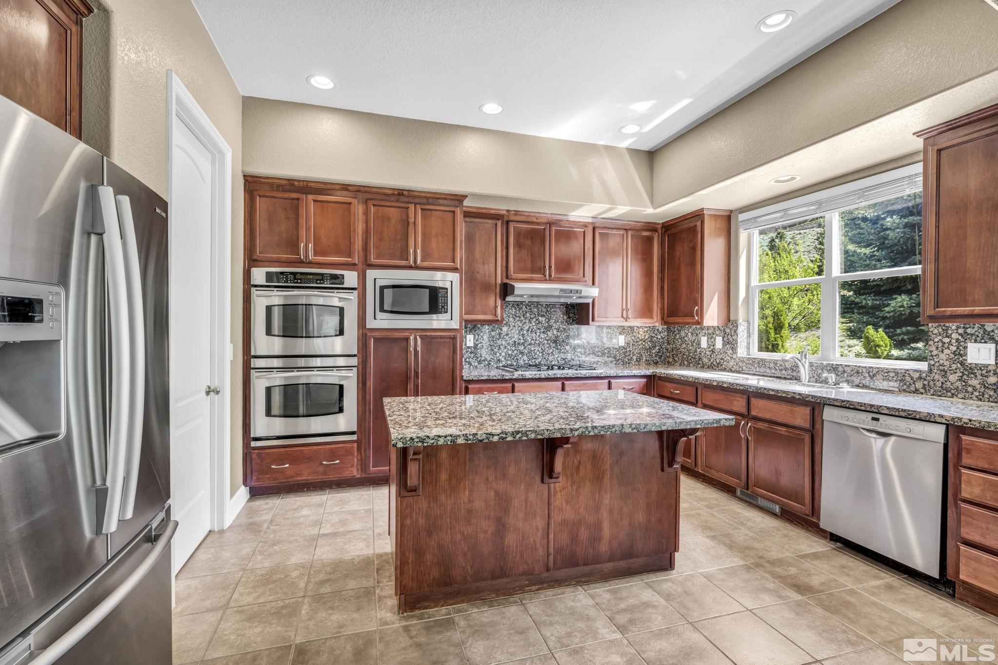 8210 Willow Ranch Trail Reno, NV 89523 - Photo 11 of 38 a kitchen with stainless steel appliances granite countertop a stove a sink and a refrigerator