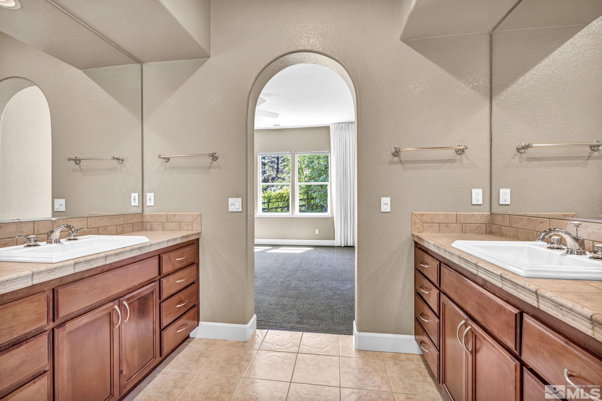 8210 Willow Ranch Trail Reno, NV 89523 - Photo 18 of 38 a spacious bathroom with a granite countertop sink a mirror and a bathtub