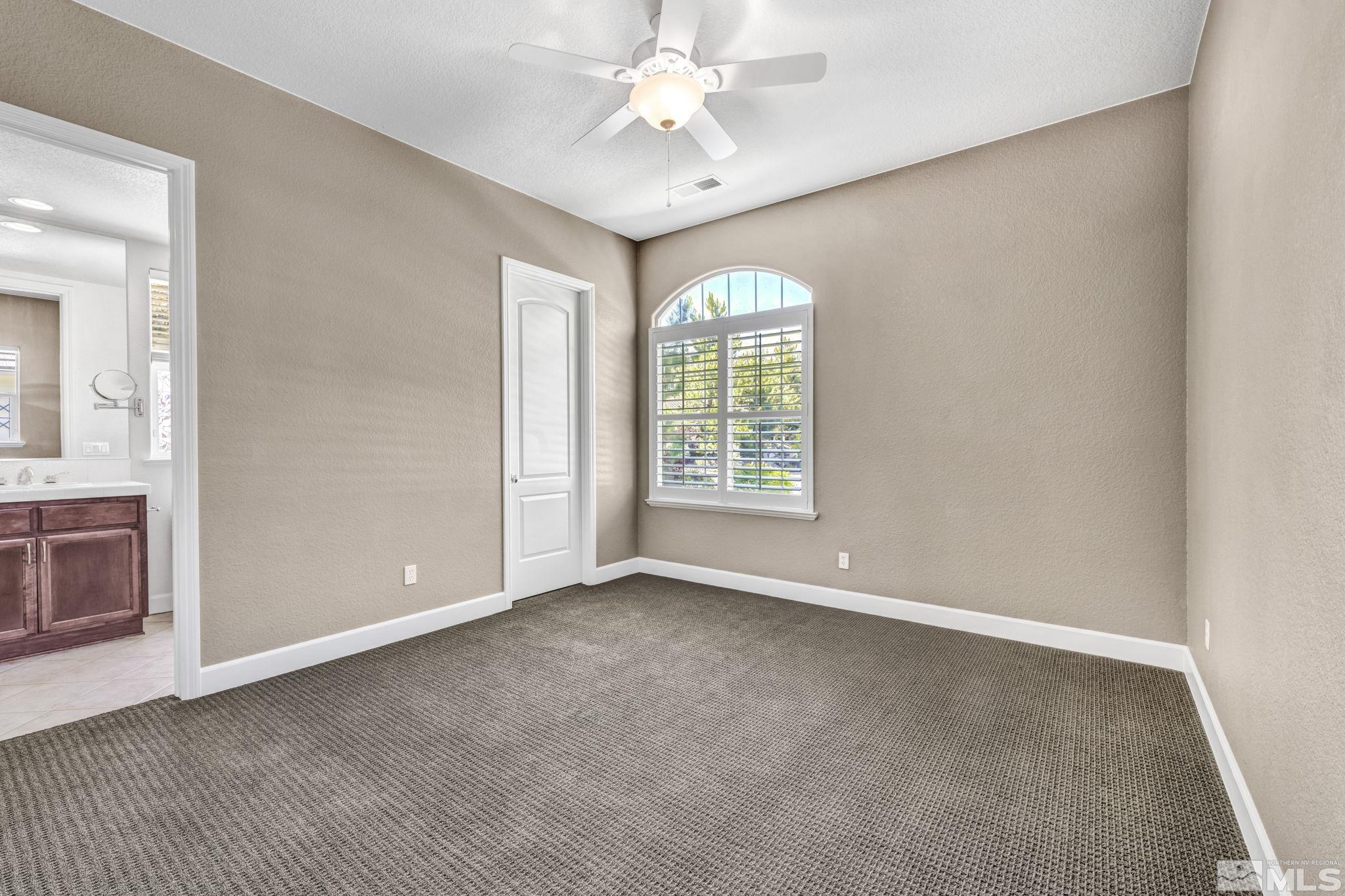 8210 Willow Ranch Trail Reno, NV 89523 - Photo 26 of 38 an empty room with chandelier fan and windows