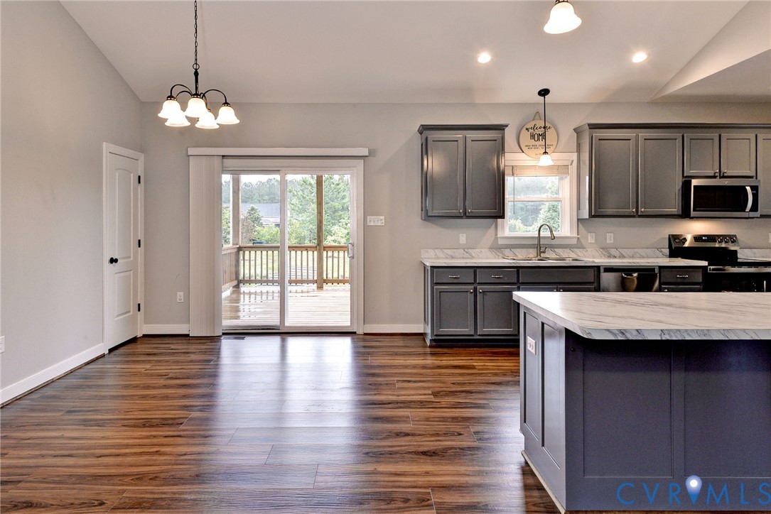 8904 Rock Cedar Road New Kent, VA 23124 - Photo 8 of 37 a kitchen with stainless steel appliances granite countertop wooden floors a stove and a refrigerator
