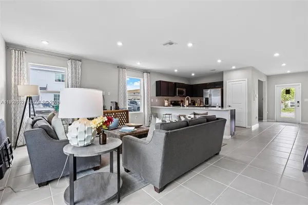 a living room with stainless steel appliances kitchen island granite countertop a couch and a view of kitchen