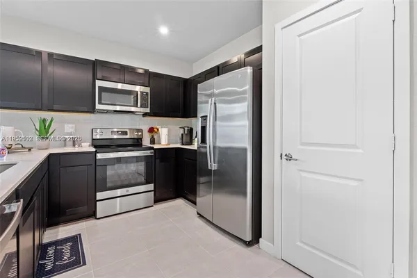 a kitchen with a refrigerator stainless steel appliances and cabinets