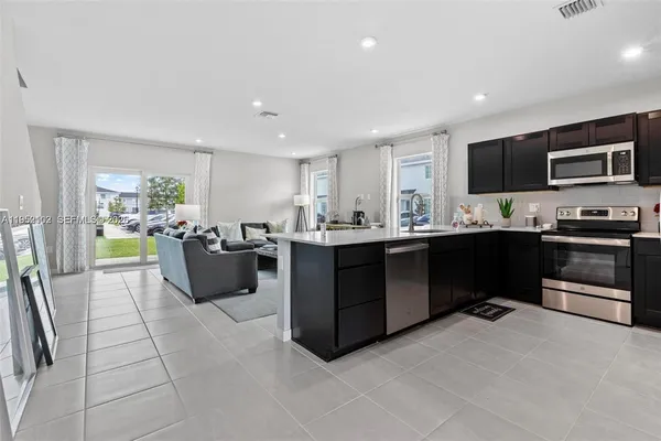a kitchen with stainless steel appliances kitchen island granite countertop a sink and cabinets