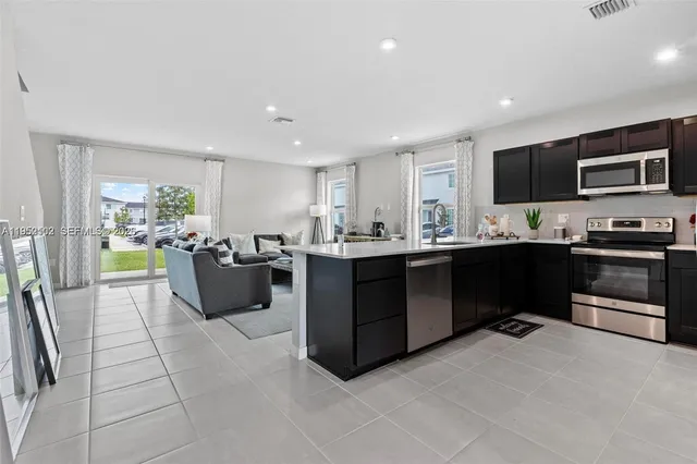 a kitchen with stainless steel appliances kitchen island granite countertop a sink and cabinets