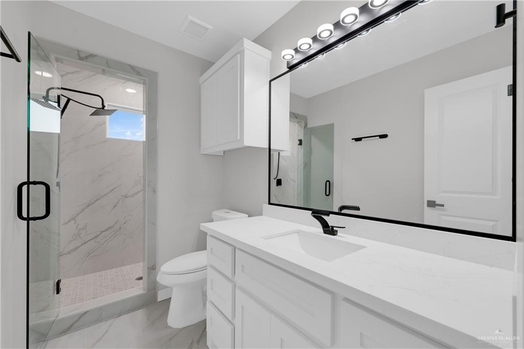 1836 Sunset Drive Mission, TX 78572 - Photo 17 of 24 a bathroom with a sink a toilet a mirror and shower