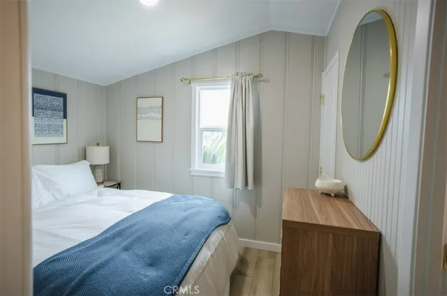 a bedroom with a bed a mirror and a window