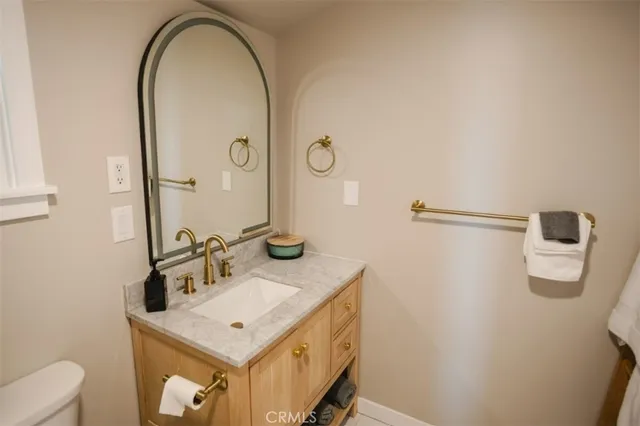 a bathroom with a sink a toilet and mirror