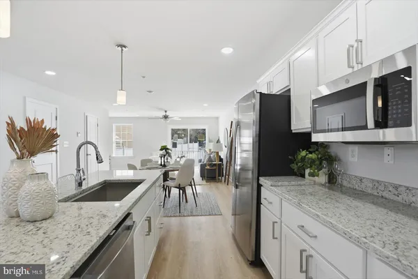 a kitchen with stainless steel appliances granite countertop a sink a stove and a wooden floors