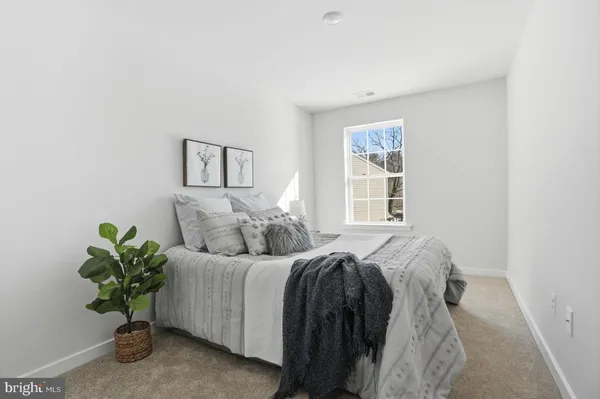 a bedroom with a bed and a potted plant