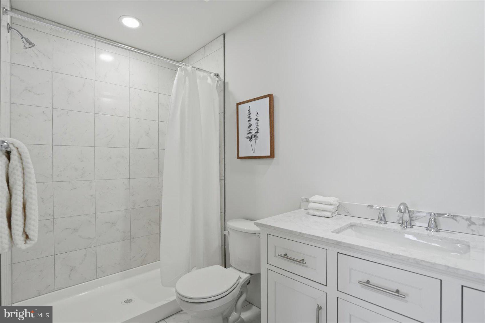 715 Hammonds Lane Baltimore, MD 21225 - Photo 18 of 29 a bathroom with a shower sink vanity mirror and toilet