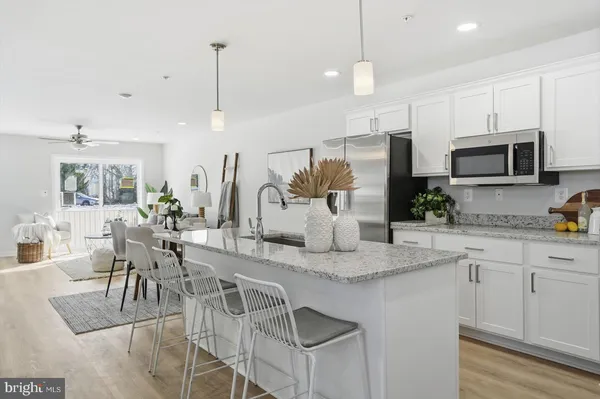 a kitchen with stainless steel appliances granite countertop a kitchen island a stove a table and chairs