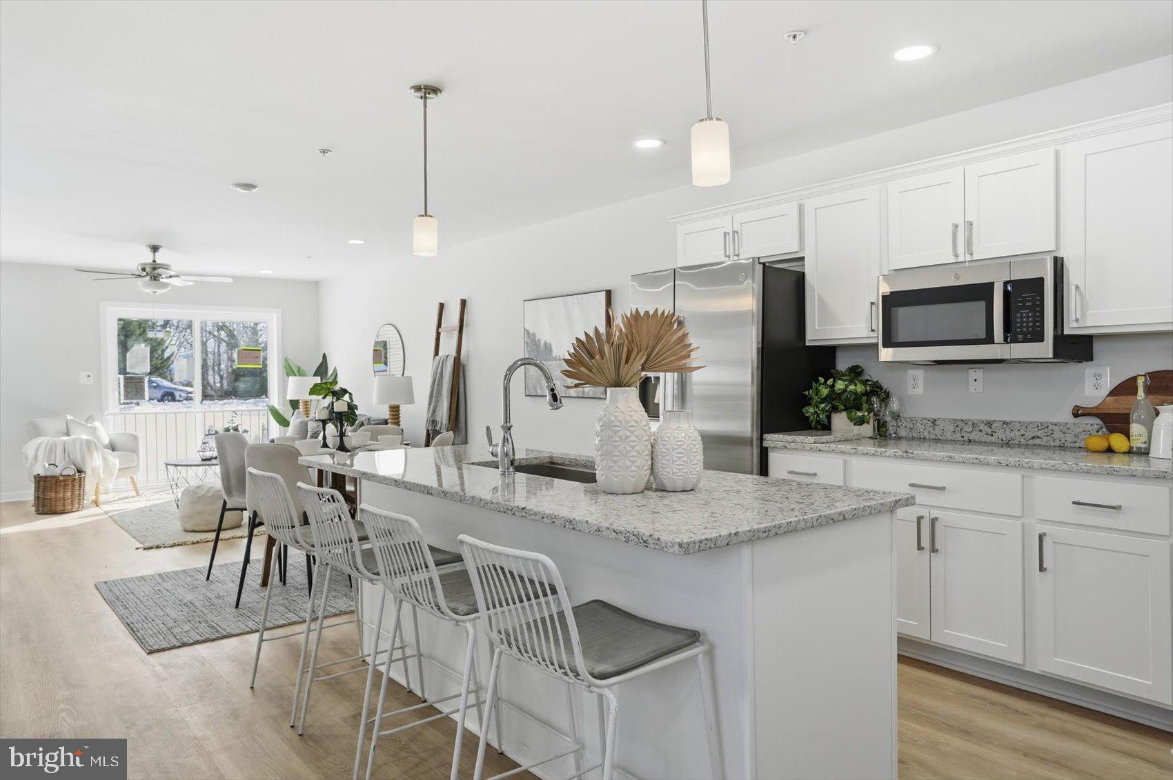 715 Hammonds Lane Baltimore, MD 21225 - Photo 3 of 29 a kitchen with stainless steel appliances granite countertop a kitchen island a stove a table and chairs