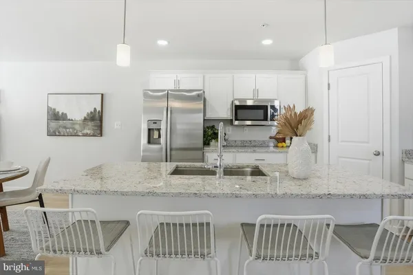 a kitchen with stainless steel appliances granite countertop a sink refrigerator and microwave