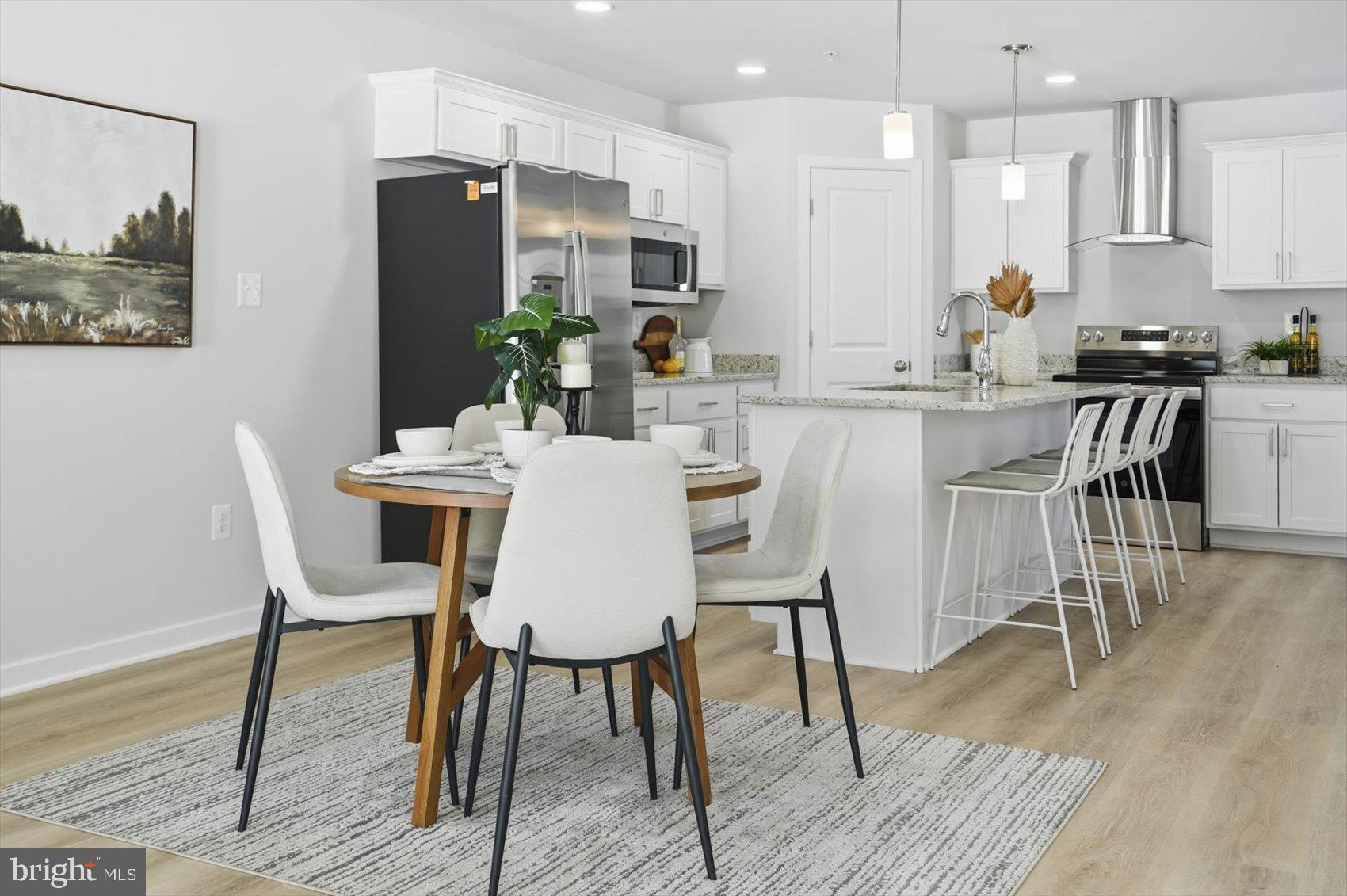 715 Hammonds Lane Baltimore, MD 21225 - Photo 7 of 29 a kitchen with stainless steel appliances kitchen island granite countertop a dining table chairs and a refrigerator