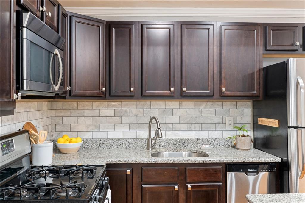 880 Glendale Terrace Northeast, Unit 9 Atlanta, GA 30308 - Photo 11 of 18 a kitchen with stainless steel appliances granite countertop a sink stove and cabinets