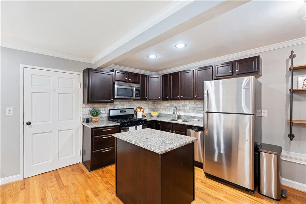 880 Glendale Terrace Northeast, Unit 9 Atlanta, GA 30308 - Photo 12 of 18 a kitchen with stainless steel appliances granite countertop a refrigerator stove microwave and sink