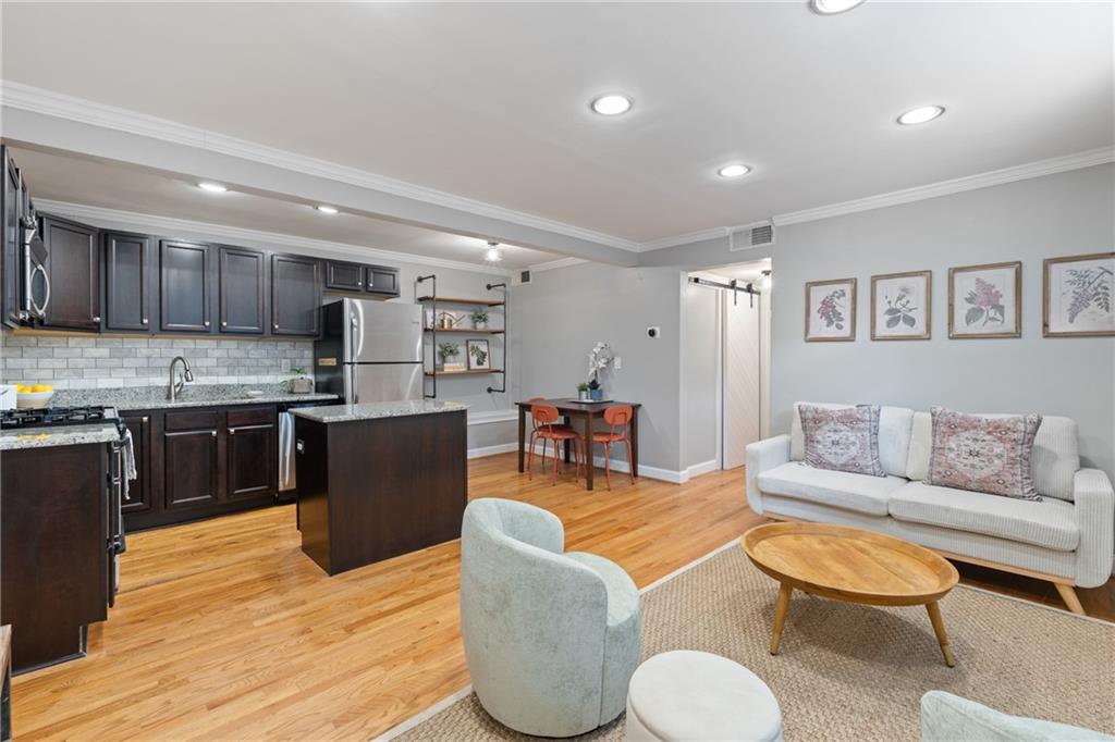 880 Glendale Terrace Northeast, Unit 9 Atlanta, GA 30308 - Photo 9 of 18 a living room with furniture kitchen and a wooden floor