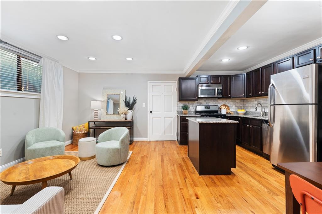 880 Glendale Terrace Northeast, Unit 9 Atlanta, GA 30308 - Photo 10 of 18 a kitchen with stainless steel appliances granite countertop a refrigerator a sink dishwasher a stove with chairs and wooden floor
