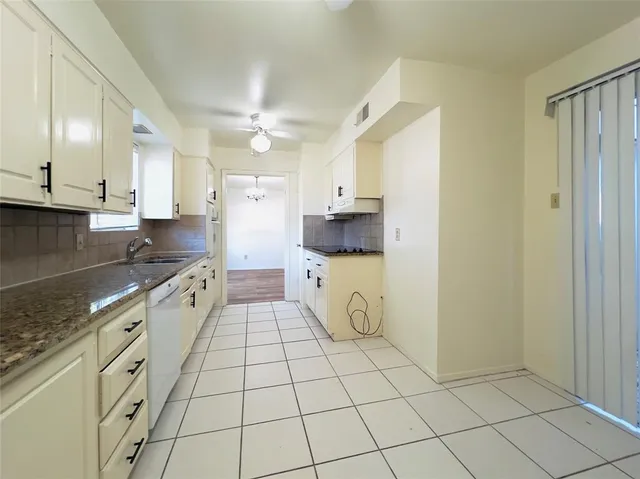 a kitchen with a sink a stove cabinets and counter space
