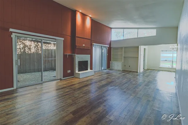 a view of empty room with wooden floor and fireplace