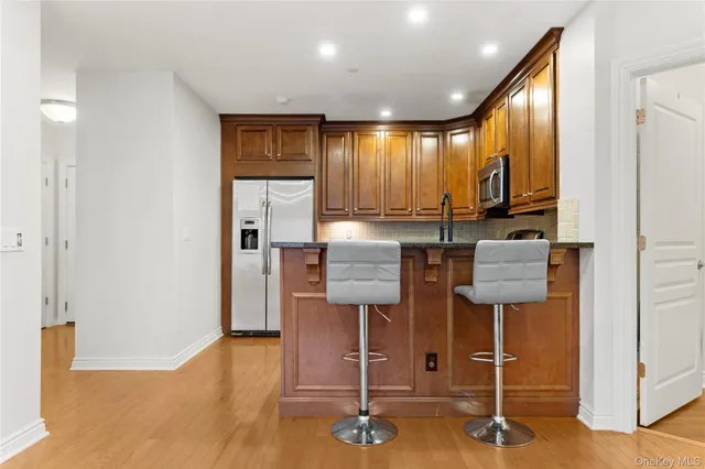 a view of a kitchen with kitchen island granite countertop wooden floor and cabinets