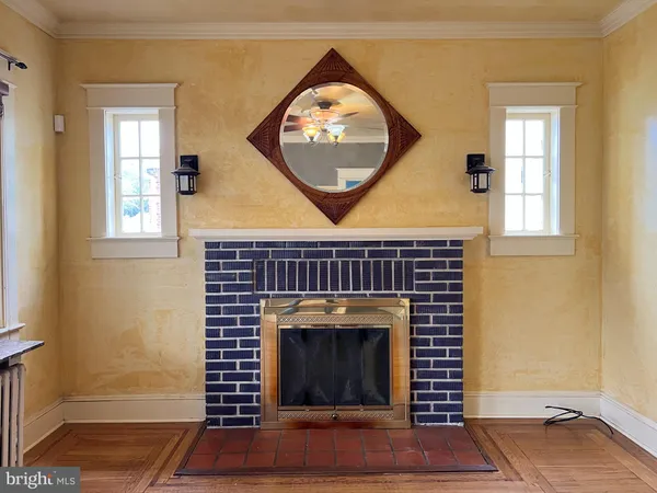an empty room with wooden floor a fireplace and a window
