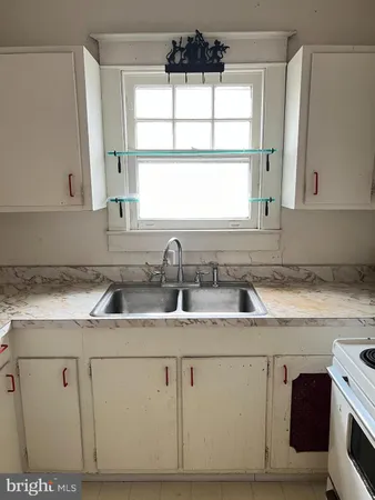 a kitchen with cabinets appliances a sink and a window