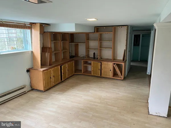 a view of an empty room with staircase door and windows