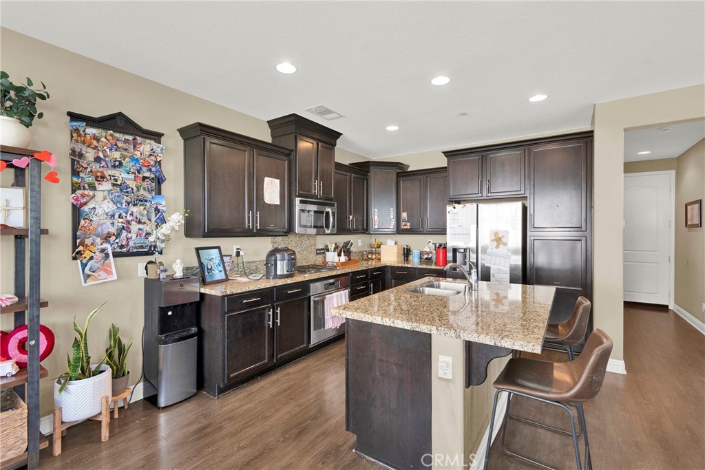 2 Sevilla Rancho Santa Margarita, CA 92688 - Photo 6 of 32 a kitchen with stainless steel appliances granite countertop a refrigerator a sink dishwasher and wooden cabinets with wooden floor