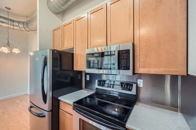a kitchen with stainless steel appliances a refrigerator a stove and white cabinets