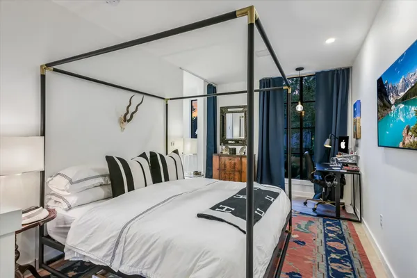 a bedroom with a bed a mirror and dresser