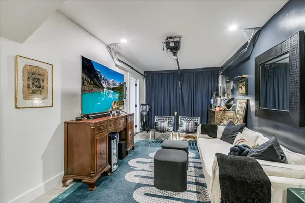 a living room with furniture a flat screen tv and a window