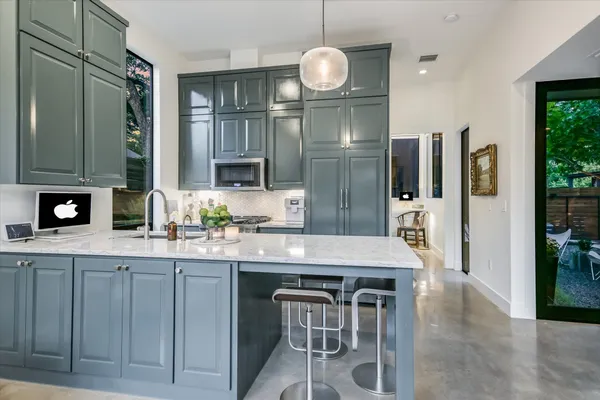 a kitchen with stainless steel appliances granite countertop a sink refrigerator stove and microwave