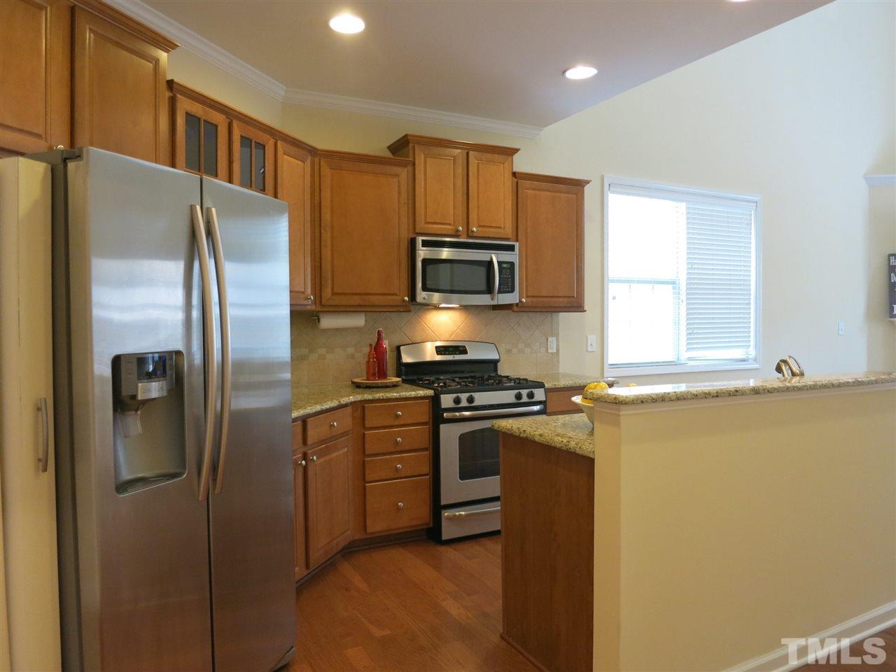 The Kitchen offers granite counters, tile backsplash, SS appls (gas range, MW, DW), 42” maple cabinets (some w/glass fronts), crown molding & island.