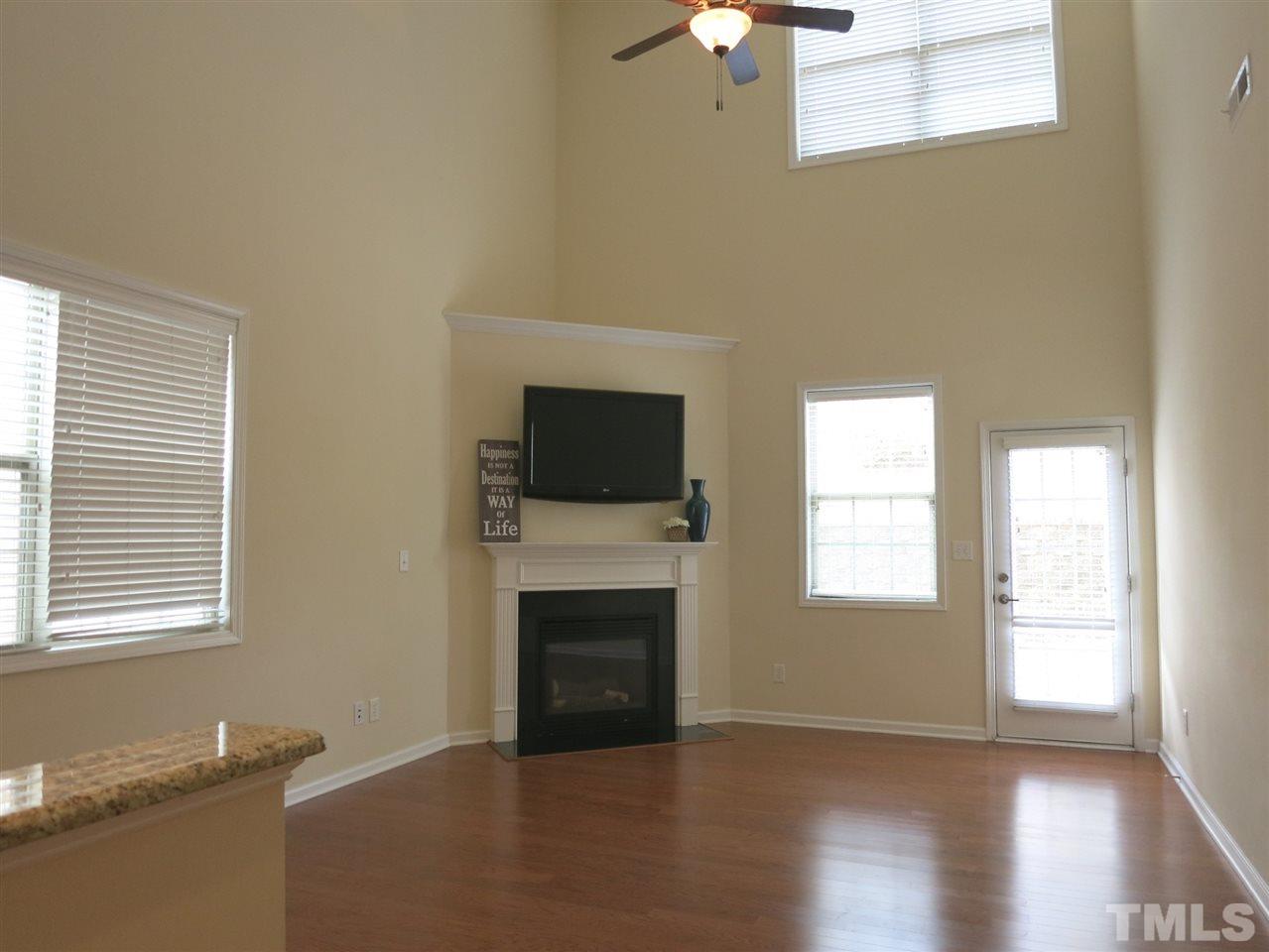 8357 Primanti Boulevard Raleigh, NC 27612 - Photo 8 of 25 The Living Rm features a 2-story tall ceiling, CF, corner gas log FP & glass door to the Patio.