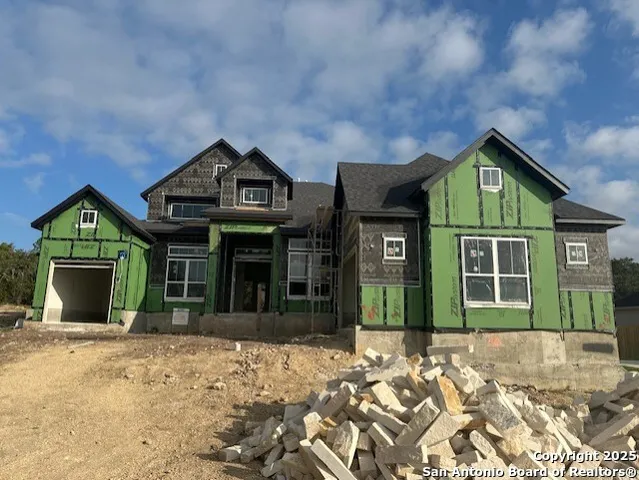 a view of a house with a yard and large tree
