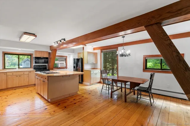 a kitchen with a table chairs and wooden floor