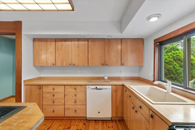 a kitchen with granite countertop a sink a stove and cabinets