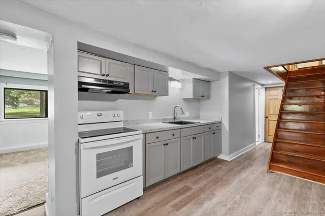 a kitchen with granite countertop a sink stainless steel appliances and cabinets