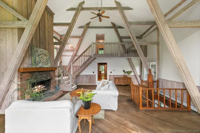 a living room with couches and a fireplace with wooden floor