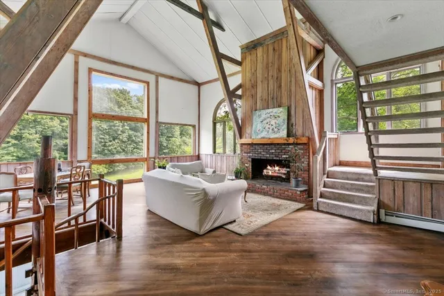 a living room with furniture a fireplace and a large window