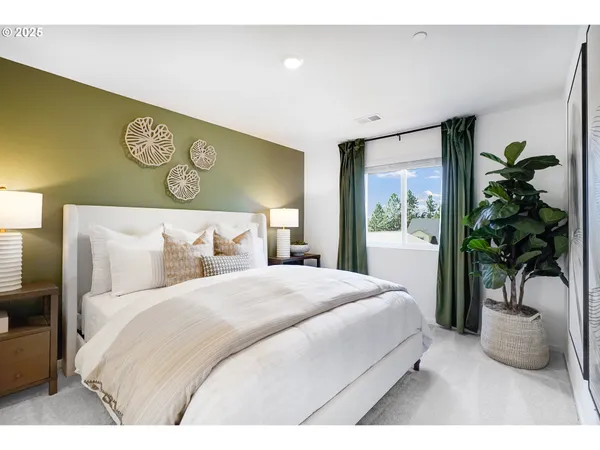 a bedroom with a large bed and a potted plant