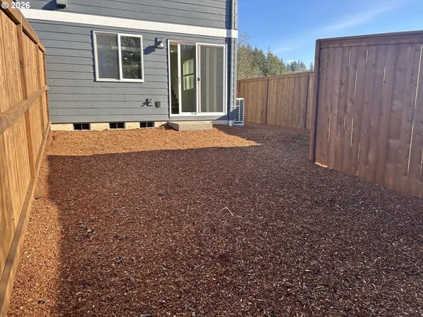 a view of a house with backyard and wooden fence