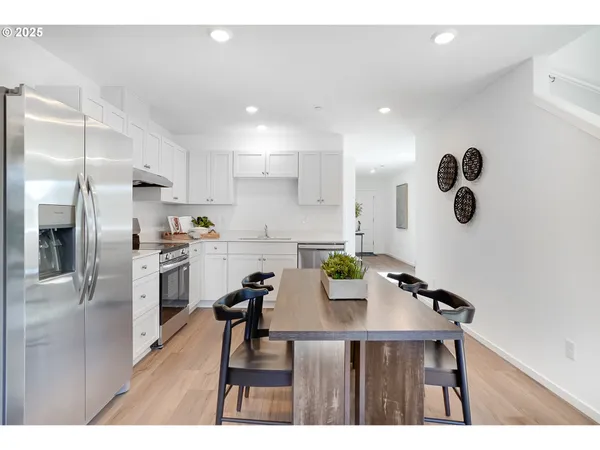 a kitchen with refrigerator cabinets dining table and chairs