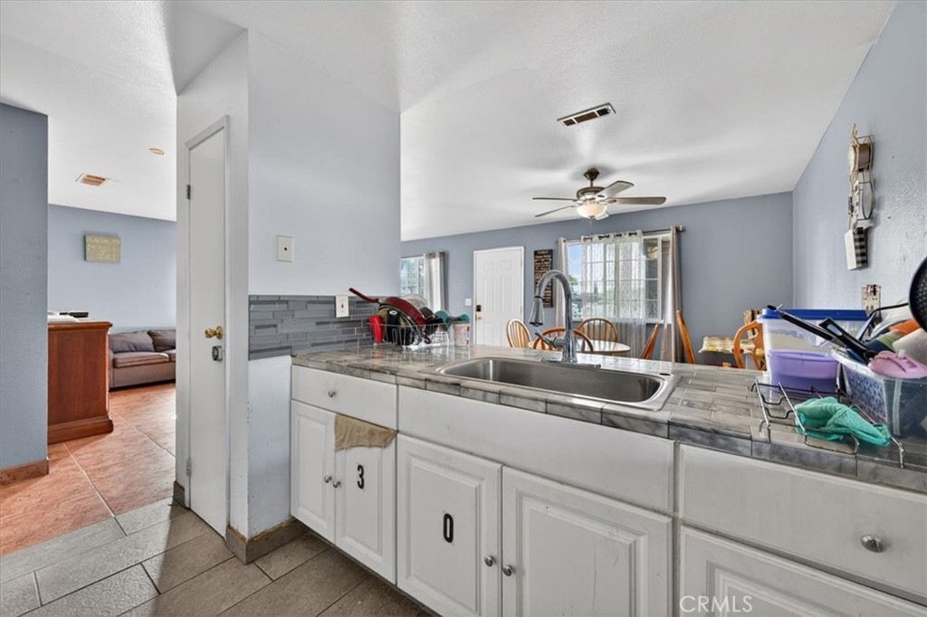 705 South C Madera, CA 93638 - Photo 22 of 50 a kitchen with kitchen island granite countertop white cabinets and white appliances